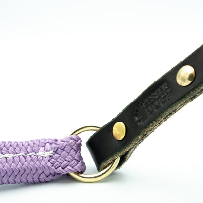 Black leather dog leash with purple rope and gold ring on a white background Aurora