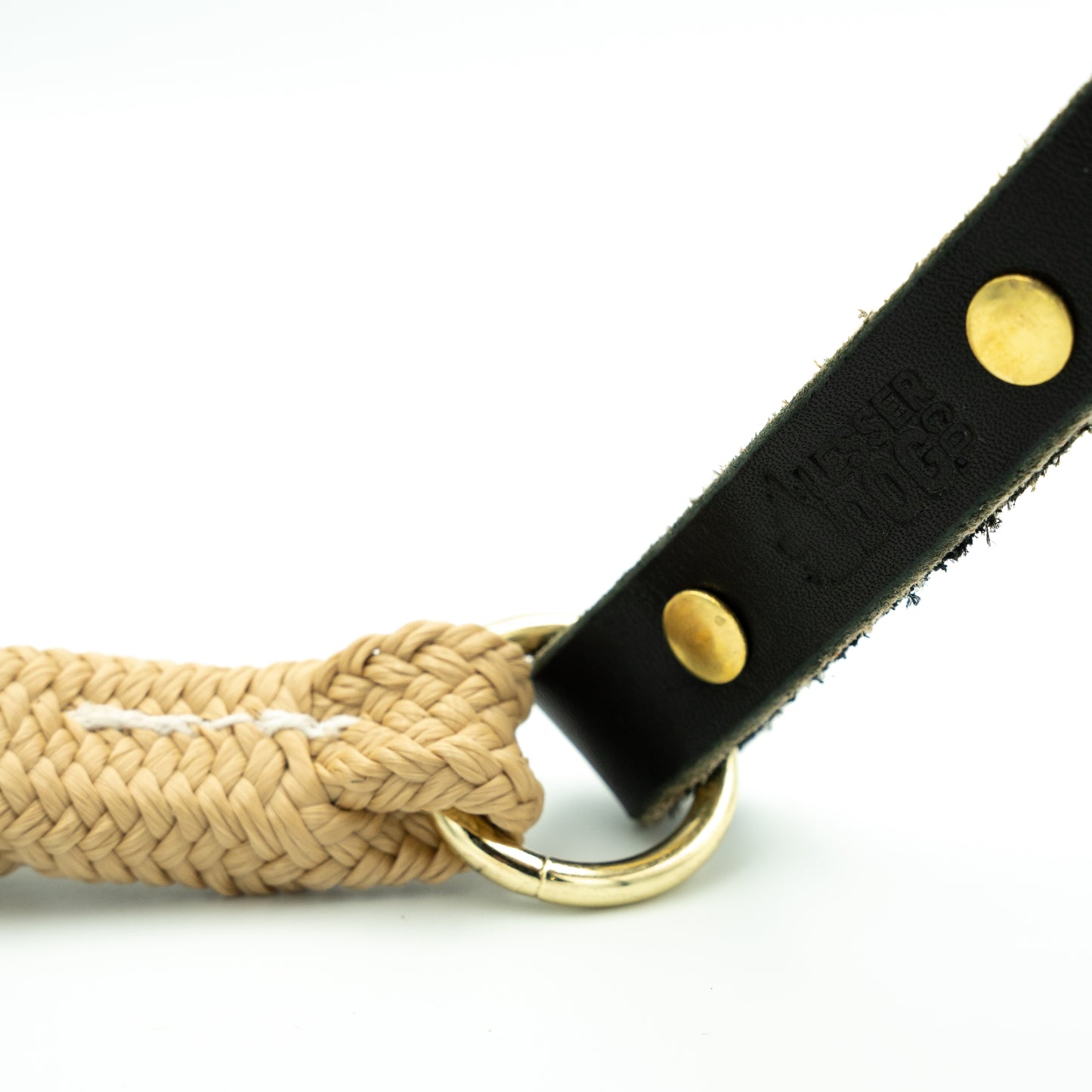 Dog leash with braided design and black leather handle on a white background Sand